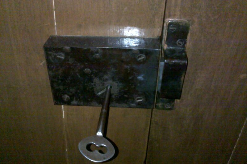 Rim lock with key in a wooden door